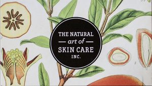 Business card with a decorative fruit and floral pattern and a black and white circle in the middle that advertises for a skin care company.