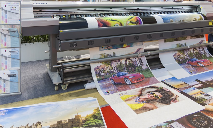 A large printer that is printing out colorful images.