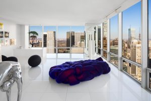 A very unique couch made from knotted and intertwining purple fabric sits in a swanky Manhattan apartment high above the city.