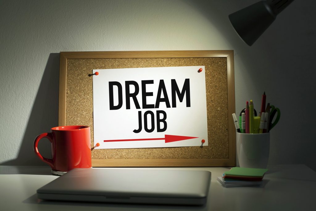 Dream job directional arrow sign note pinned on bulletin board in office interior