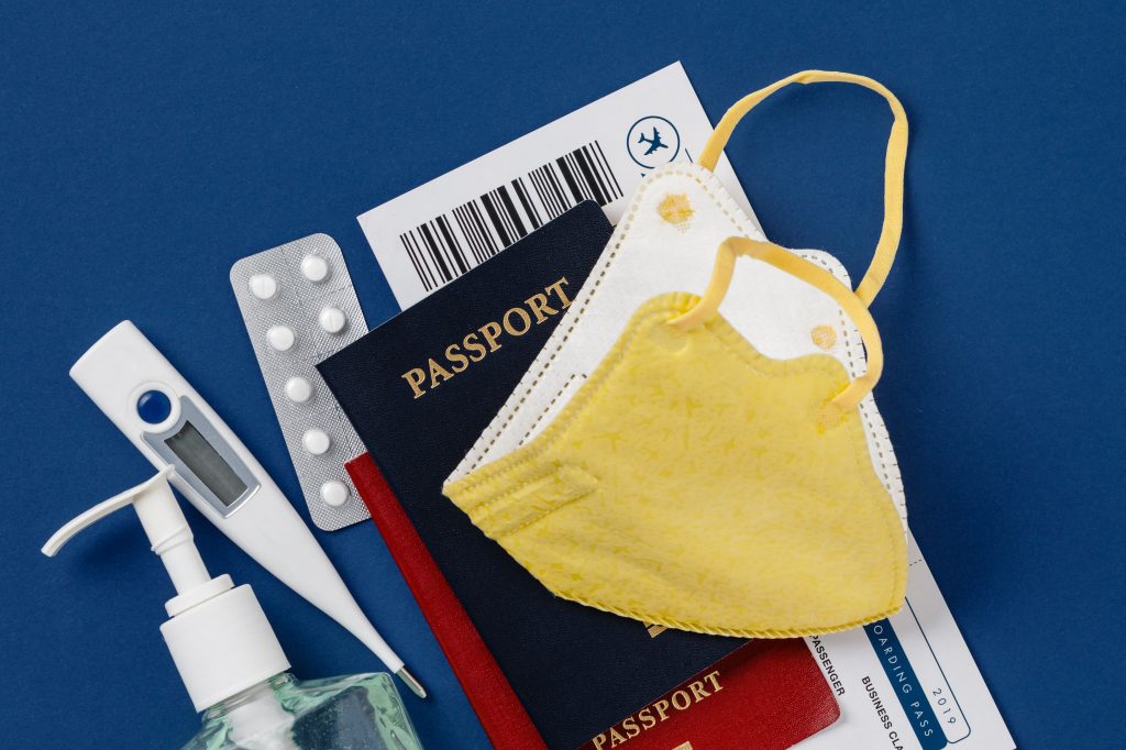 Coronavirus and travel concept. Passports, airplane tickets, sanitizer, thermometer and medical mask flat lay. Border control and quarantine of tourists infected with coronavirus. Flight cancellation coronavirus pandemic. Coronavirus Covid-19