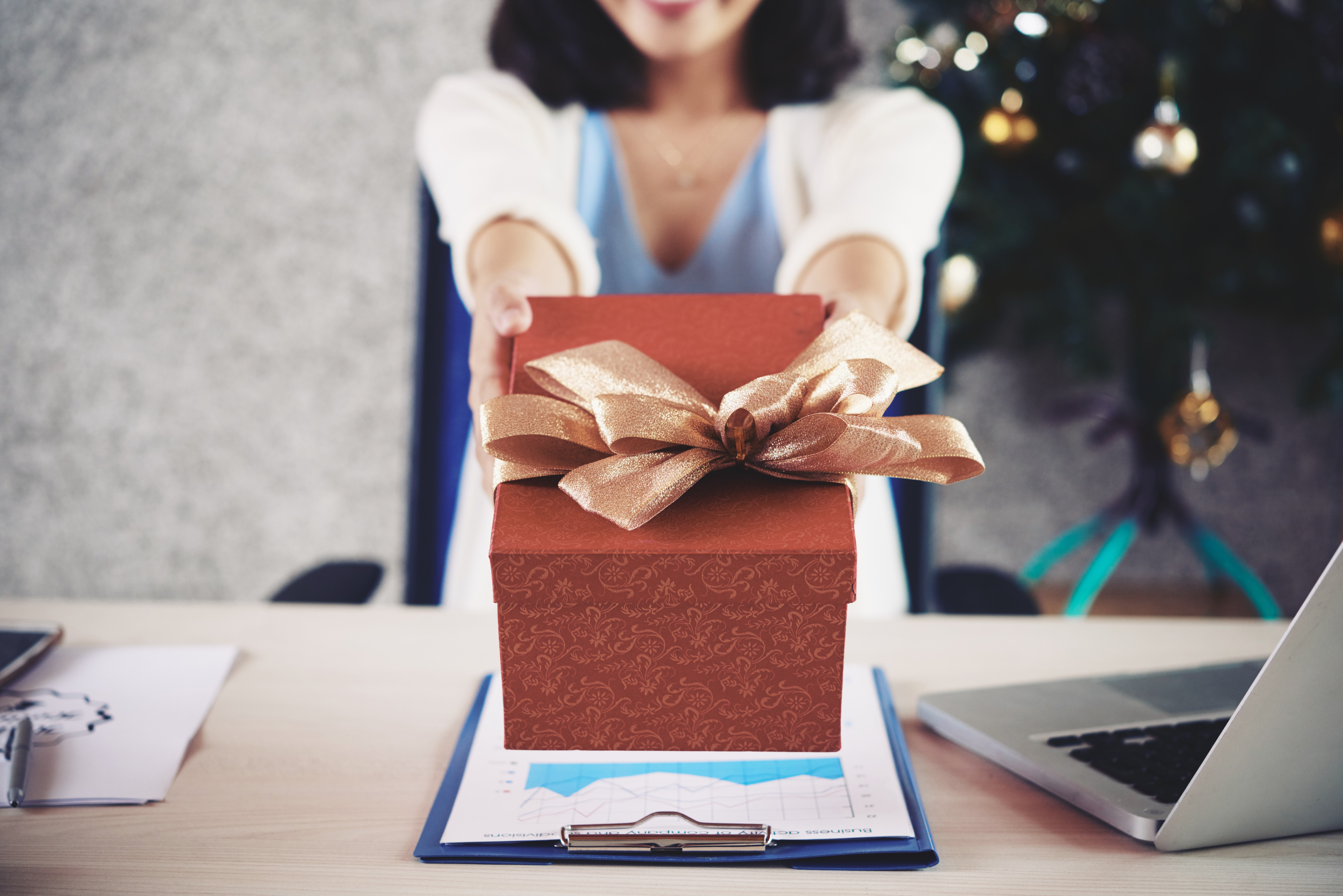 Cropped image on female entrepreneur outstretching hands with Christmas present