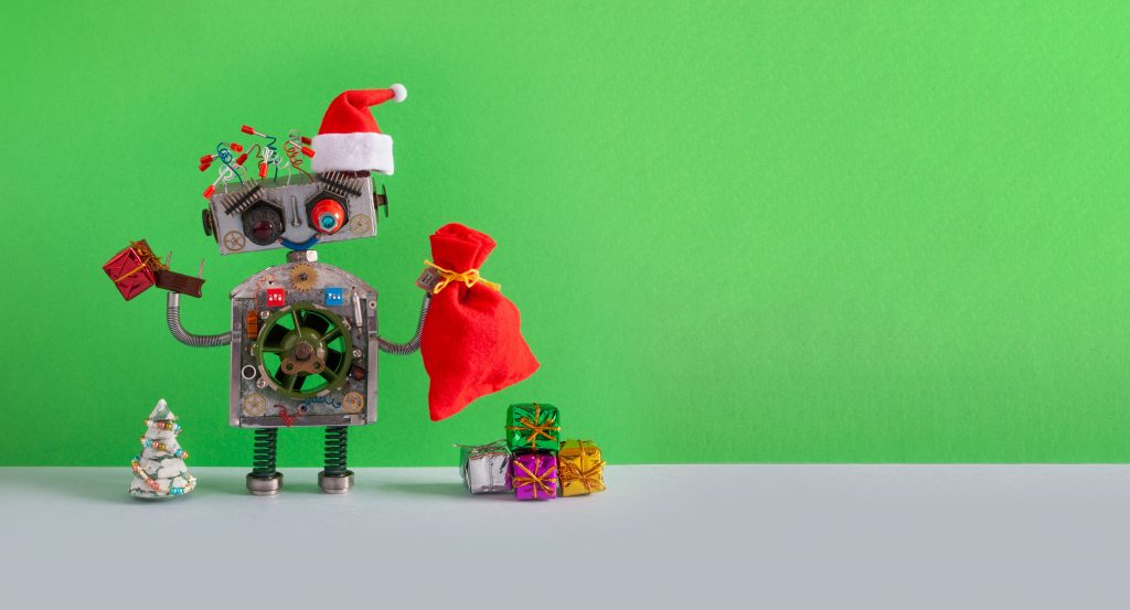 Santa Claus steampunk robotic toy with gifts bag on green background. Festive Christmas New year greeting card mockup with funny robot dressed red Santa hat. empty space backdrop for text.