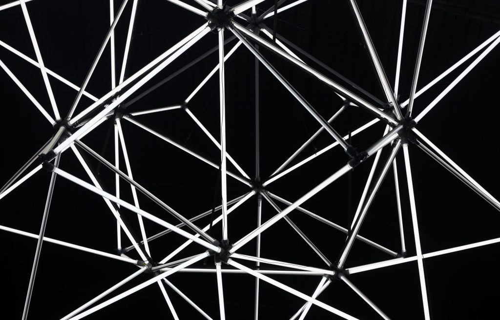 Abstract geometric black background made of light tubes. Black and white colors.