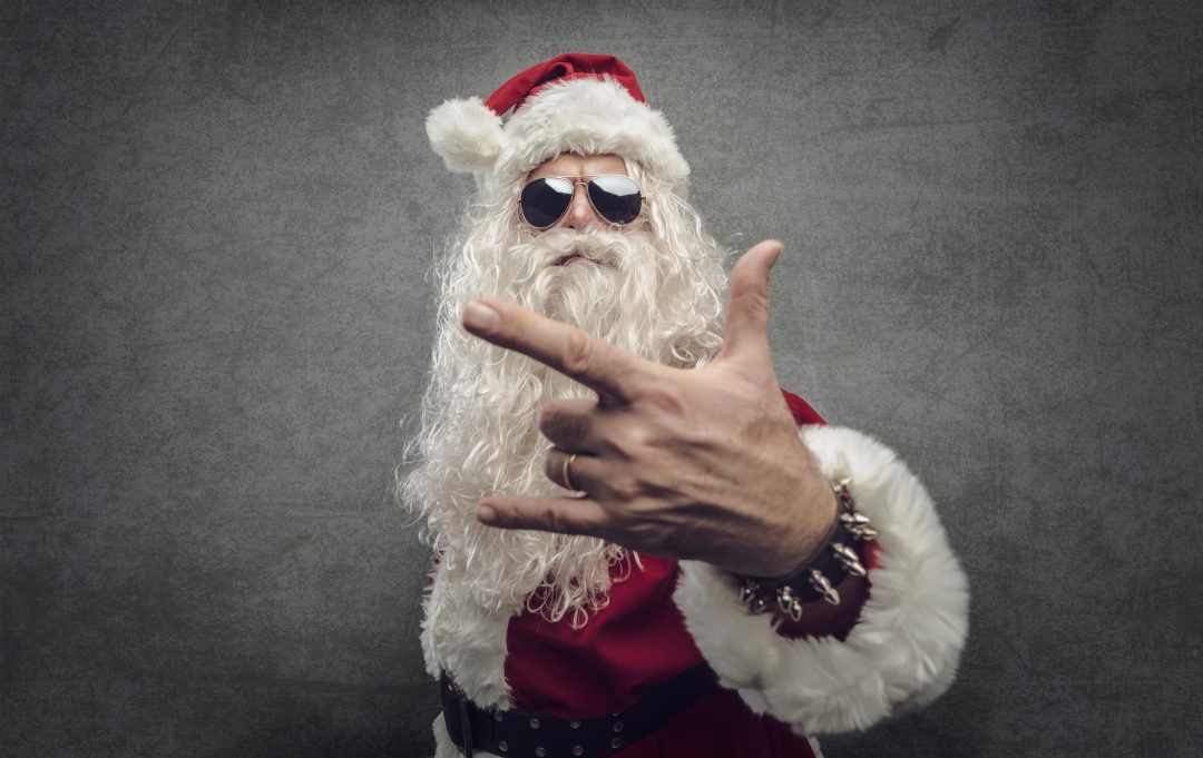 Cool Santa Claus making an heavy-metal gesture and staring at camera: rock Christmas concept