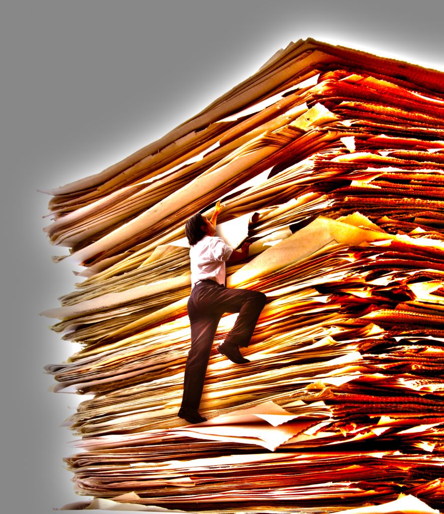 A Business Men Climbing a Pile of Papers